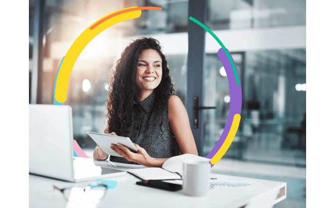 Foto de mujer joven sentada en su oficina, feliz porque pudo adquirir el crédito de tesoreria para corporaciones con Bancolombia